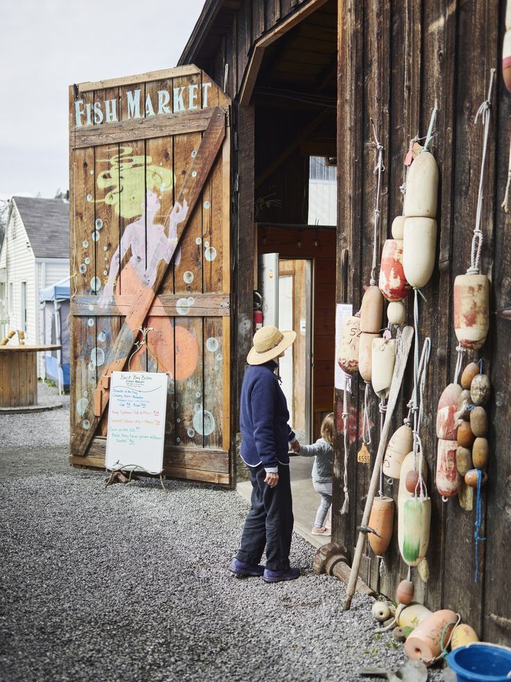 a man standing next to a wooden building