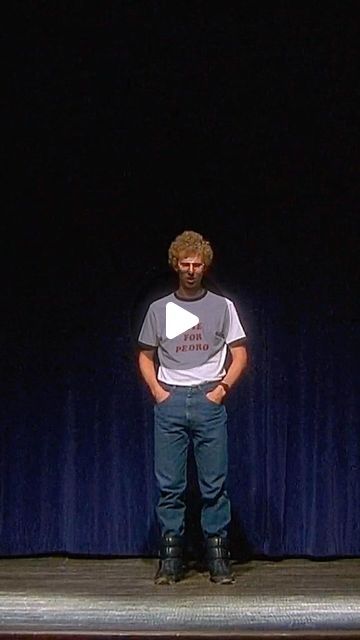 a man standing on a stage with his hands in his pockets