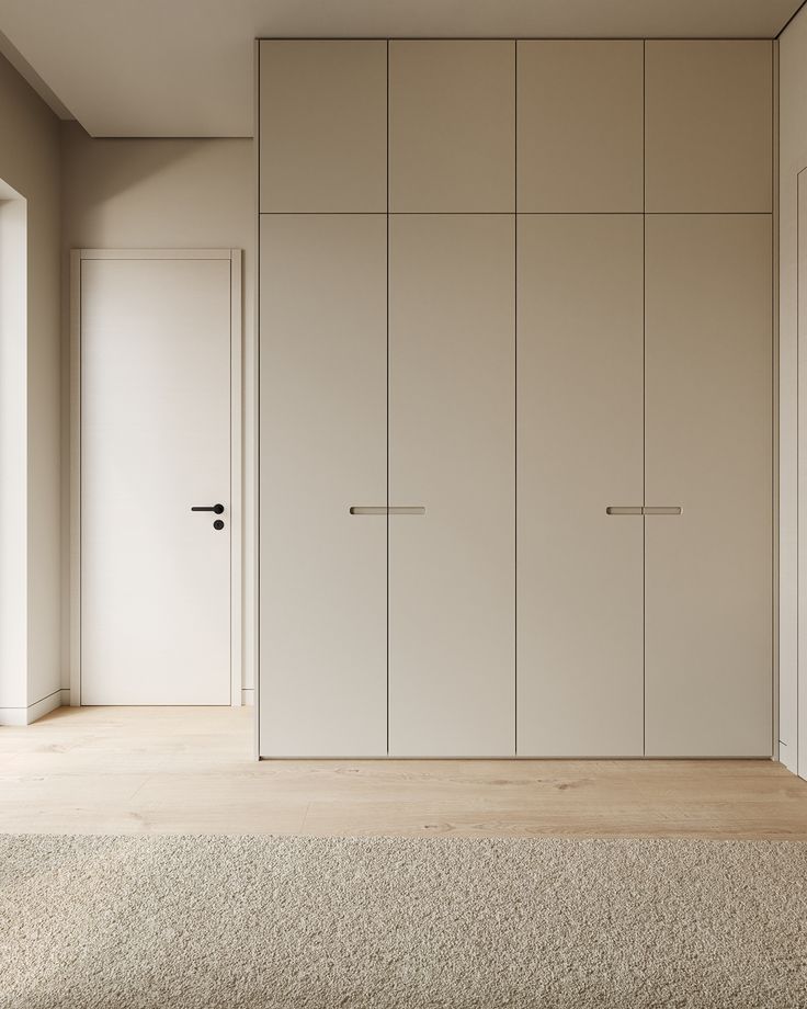 an empty room with white cupboards and carpet on the floor in front of it