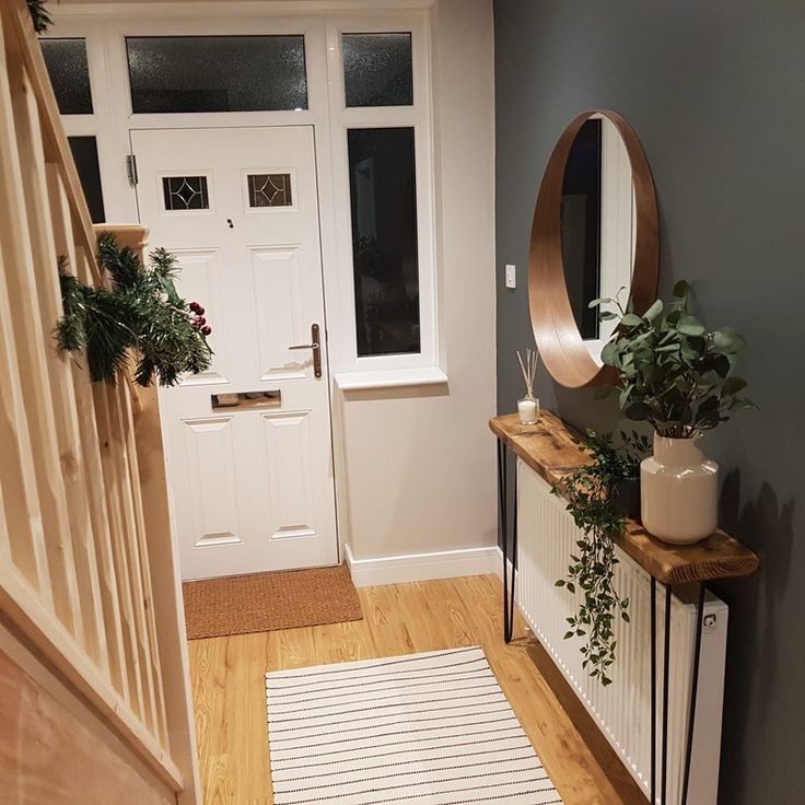 an entryway with potted plants and a mirror on the wall next to it