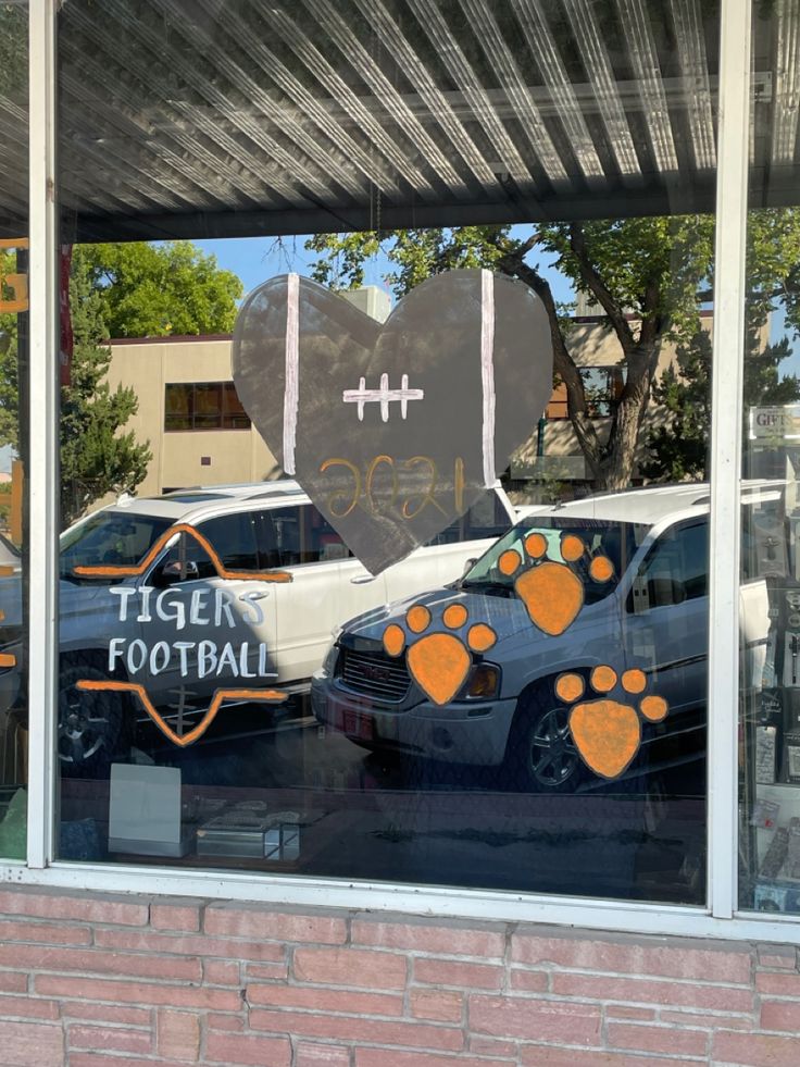 a window with an orange and white paw print on the glass, in front of a brick building