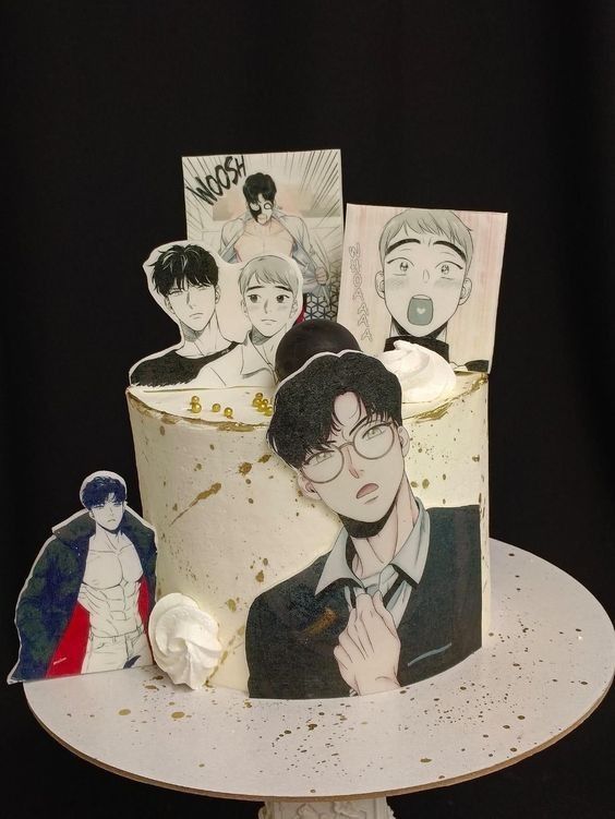 a cake decorated with anime characters on top of a white plate and some cutouts