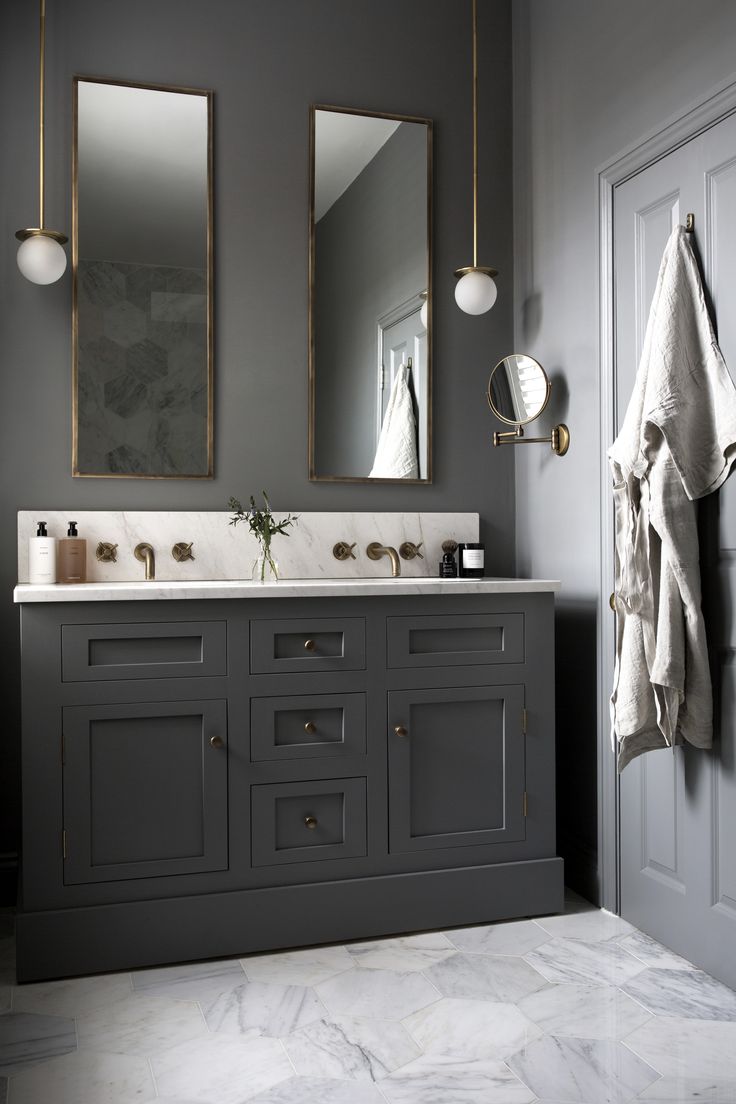 a bathroom with two sinks and mirrors on the wall