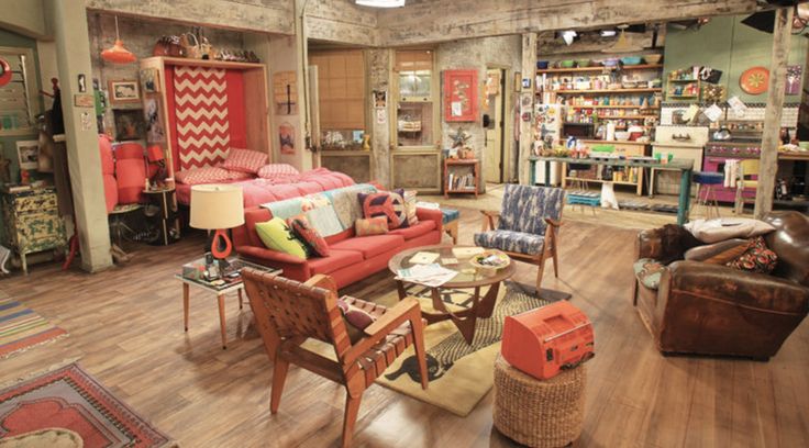 a living room filled with furniture and lots of books on the shelves in front of it