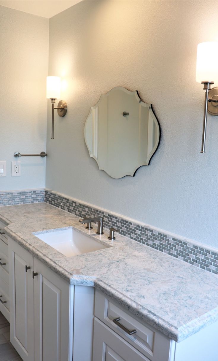 a bathroom with two sinks and a large mirror above the sink is pictured in this image