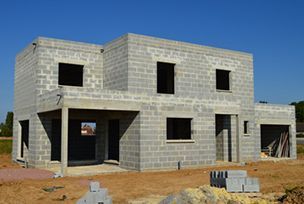 a house being built in the middle of a construction site with concrete blocks on the ground