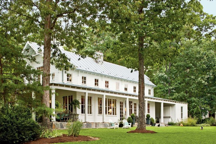 a large white house surrounded by trees and grass