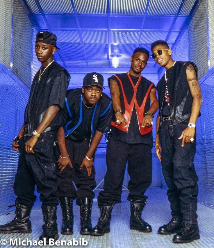 four young men standing in front of a blue light