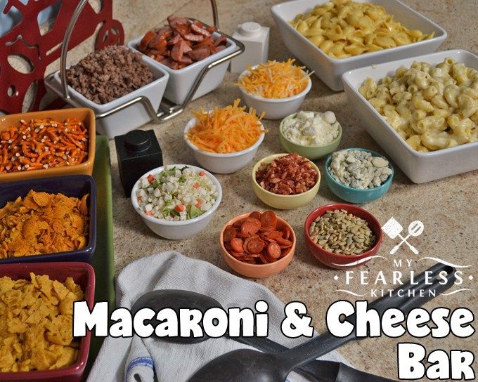 macaroni and cheese bar is displayed on a table with other foods in bowls