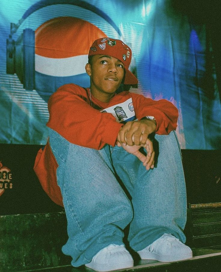 a young man sitting on top of a bench in front of a tv screen wearing headphones