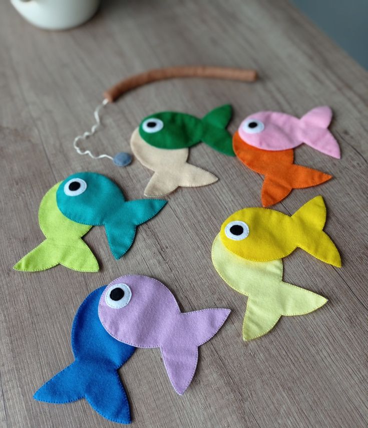 several different colored fish sitting on top of a wooden table