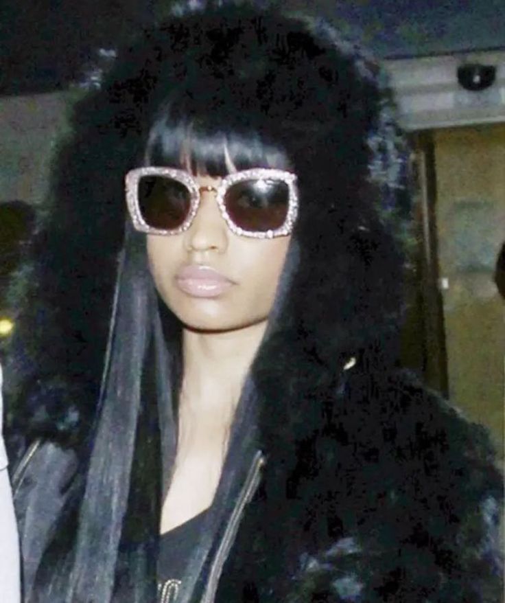 a woman wearing sunglasses and a fur coat is seen in this undrecognized image