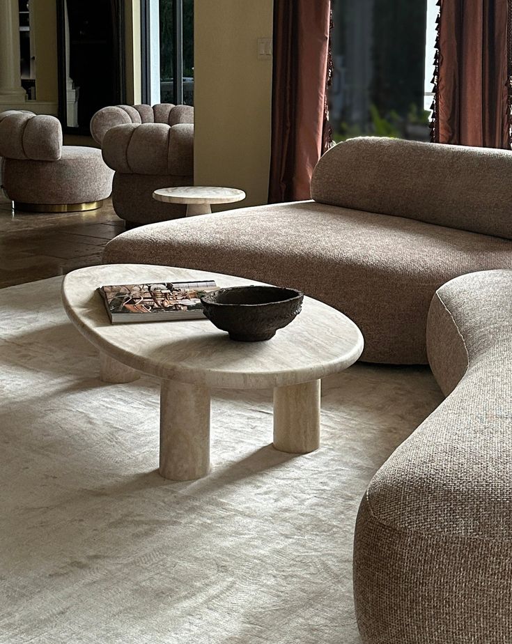 a living room filled with furniture and a bowl on the coffee table