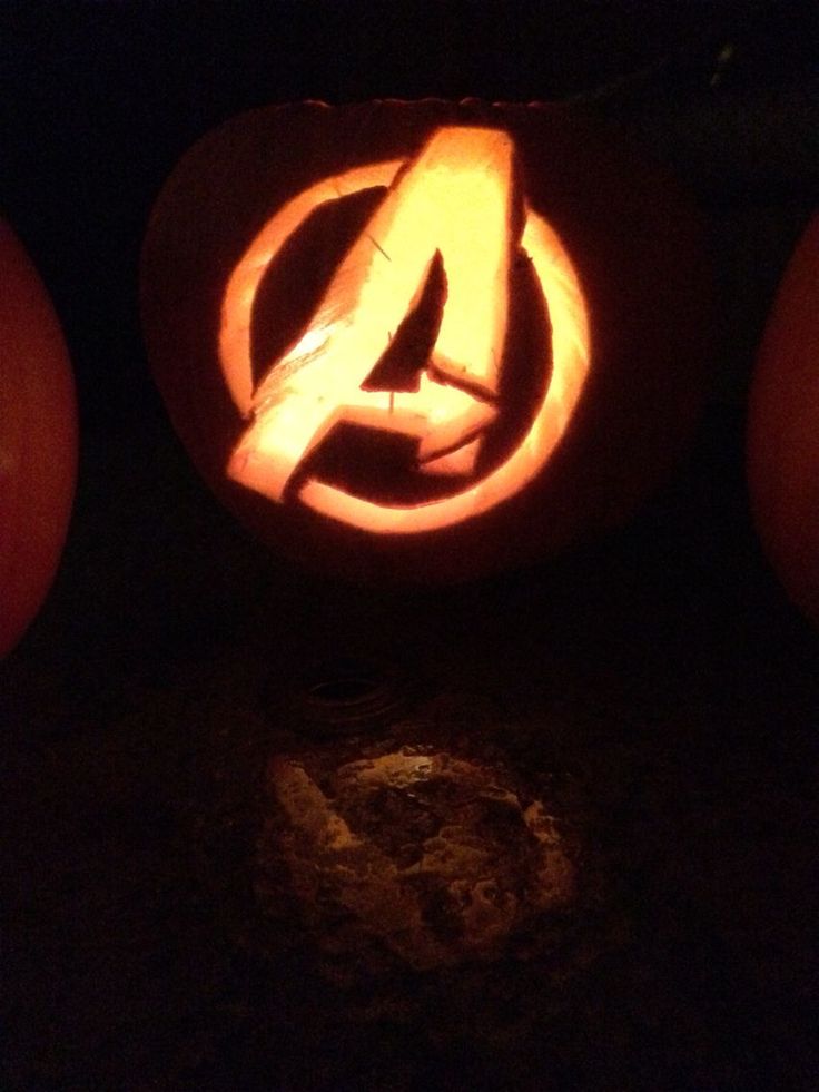 two pumpkins with the avengers symbol carved into them