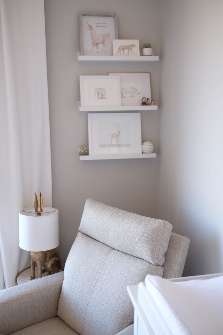 a baby's room with white furniture and shelves on the wall