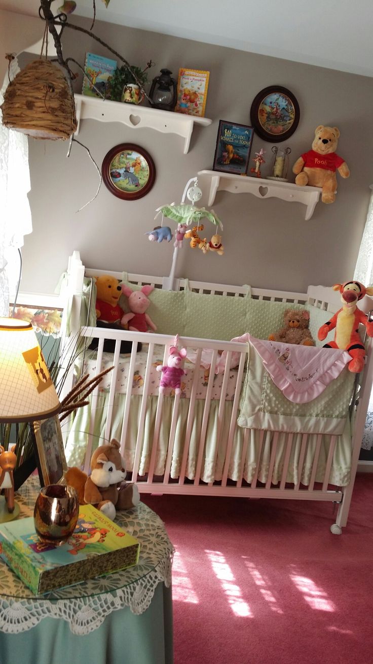 a baby crib in the corner of a room filled with stuffed animals and toys