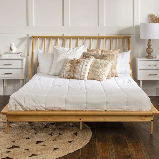 a bed with white sheets and pillows on top of it in a bedroom next to two nightstands