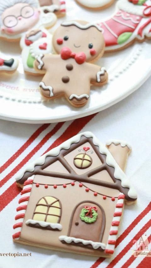 two plates with decorated cookies on them sitting on a red and white striped tablecloth