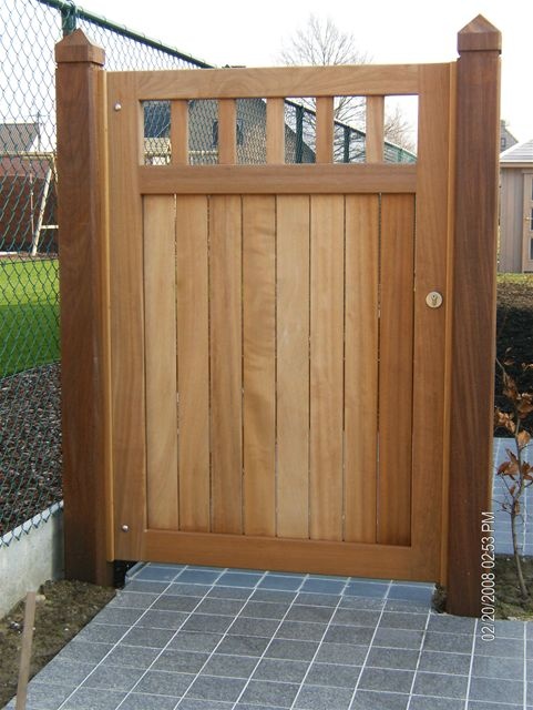 a wooden gate in front of a fence