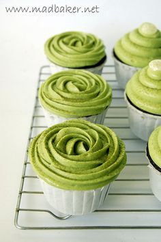 cupcakes with green frosting sitting on a cooling rack