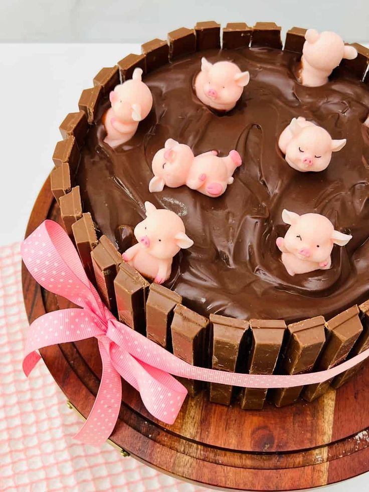 a cake with chocolate frosting and pig figurines on top