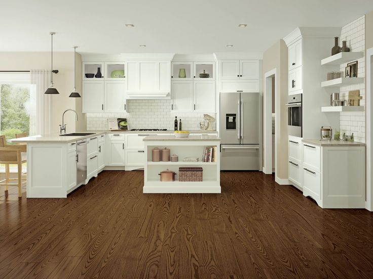 a large kitchen with white cabinets and wood flooring is pictured in this image from the front view