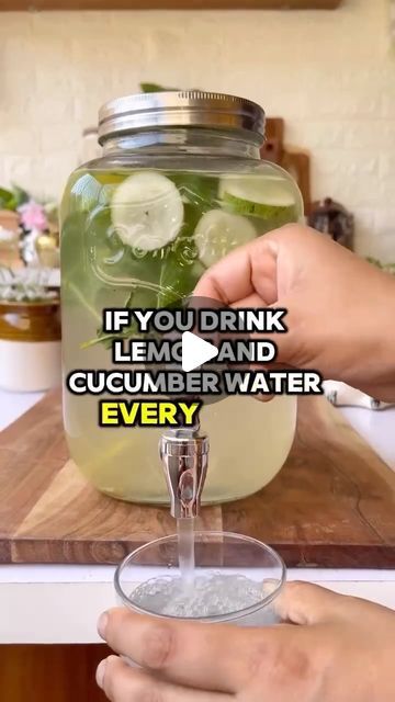 someone is pouring water into a jar with cucumber in it