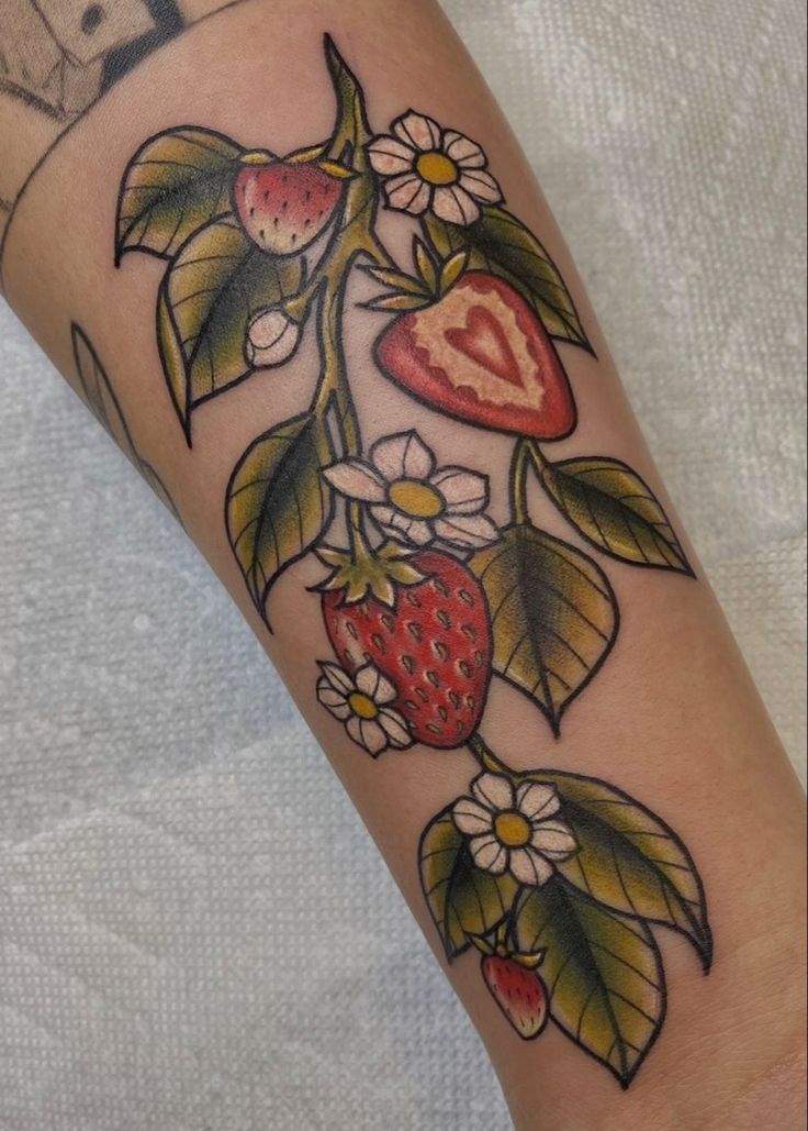 a strawberry with leaves and flowers on the arm