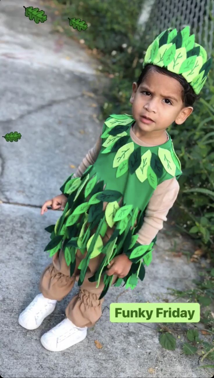 a little boy dressed up in a green leafy costume and white tennis shoes with the words funky friday on it