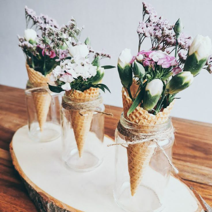 three ice cream cones with flowers in them