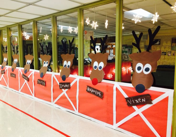 several reindeer heads are on display in front of a wall with red and white paper