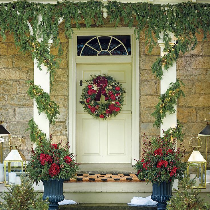 two blue vases filled with flowers sitting on the front porch next to a white door