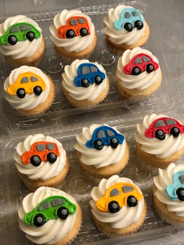 cupcakes with frosting and cars on them in a plastic container, ready to be eaten