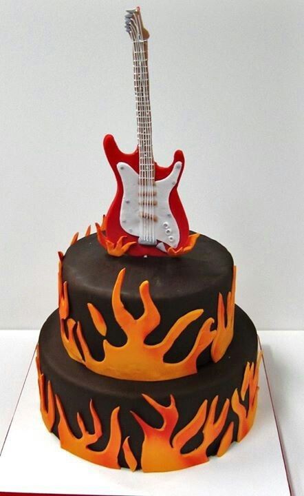 a cake with a guitar on top and flames around the edges, as if it were made out of fondant