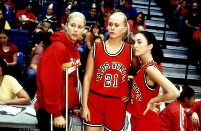 three women in red basketball uniforms standing next to each other