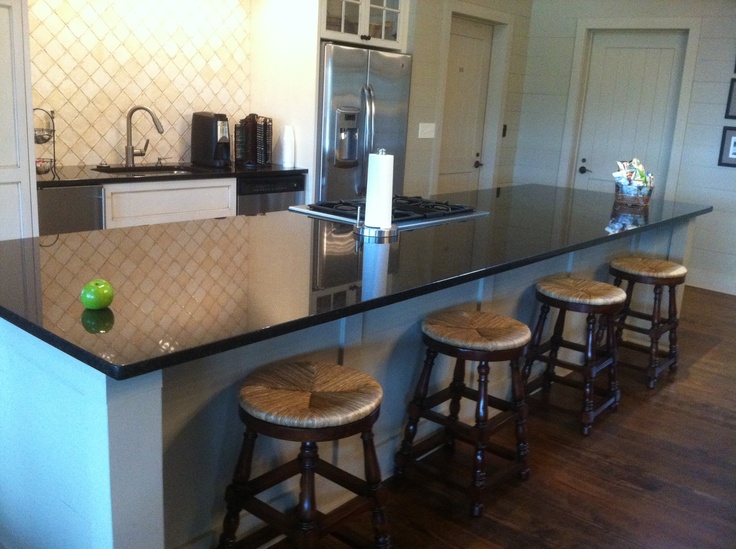 a kitchen island with four stools next to it