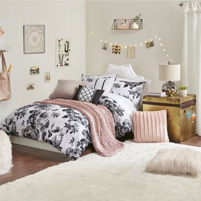 a white and black bedroom with lots of decorations on the wall, rugs and bedding