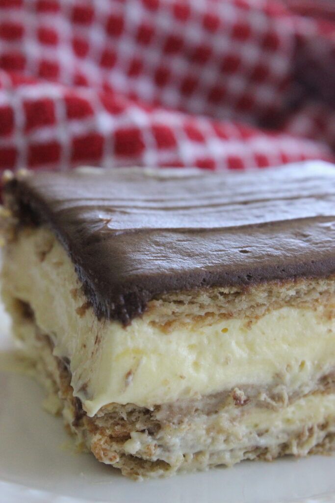 a piece of cake sitting on top of a white plate next to a red and white checkered napkin