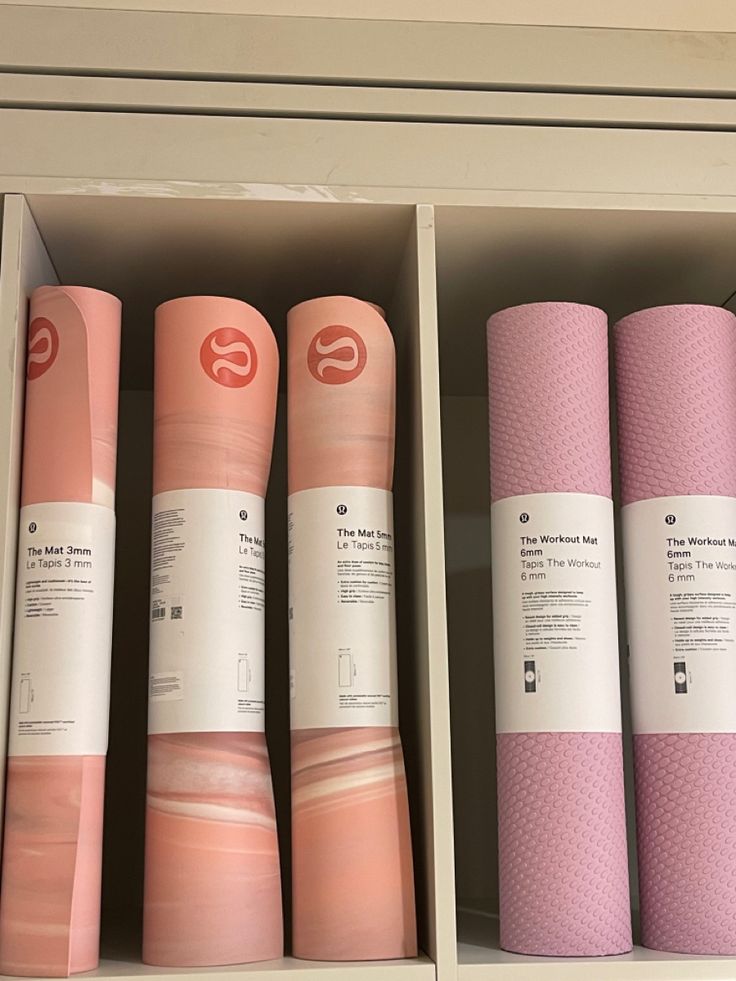 yoga mats are lined up on shelves in a storage area at a health and fitness store