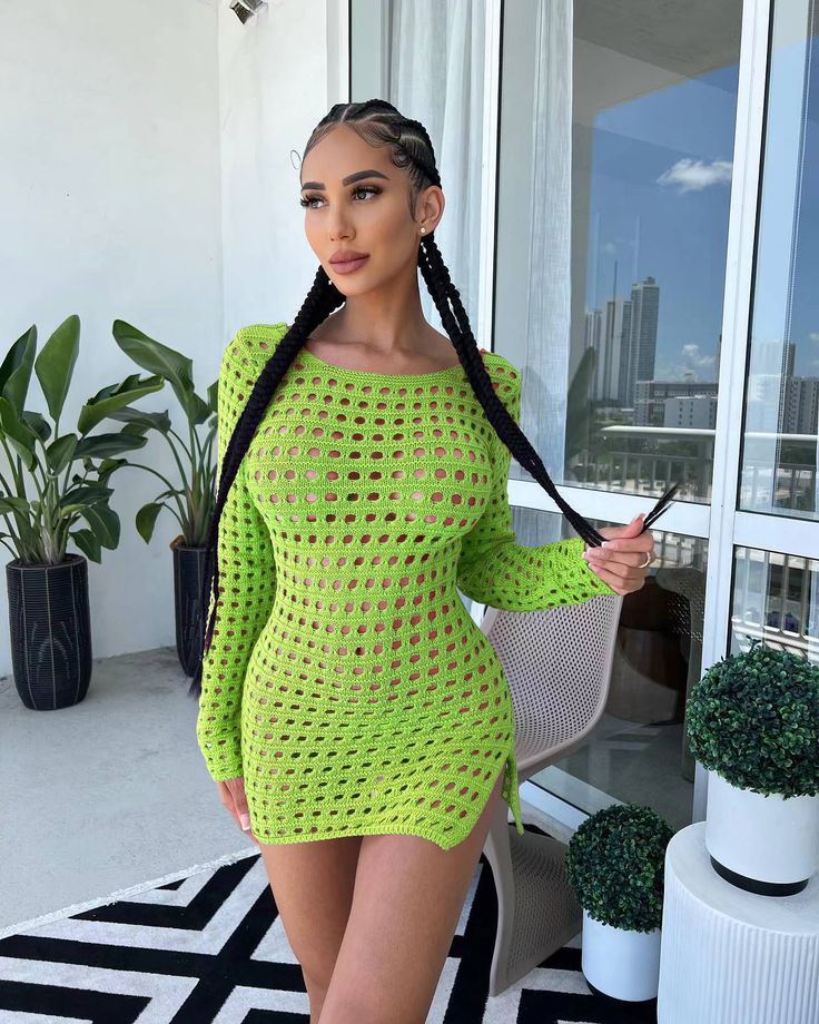 a woman in a neon green bodysuit posing for the camera with her long braids