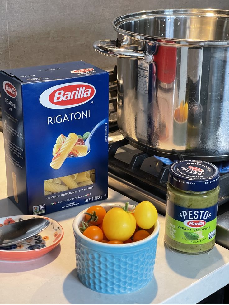 some food is sitting on the counter next to a pot and a box of pasta