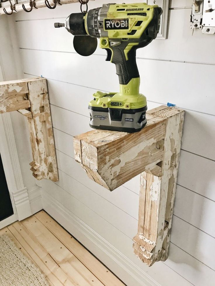 a cordless driller sitting on top of a piece of wood in a room