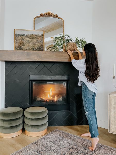 a woman standing in front of a fire place