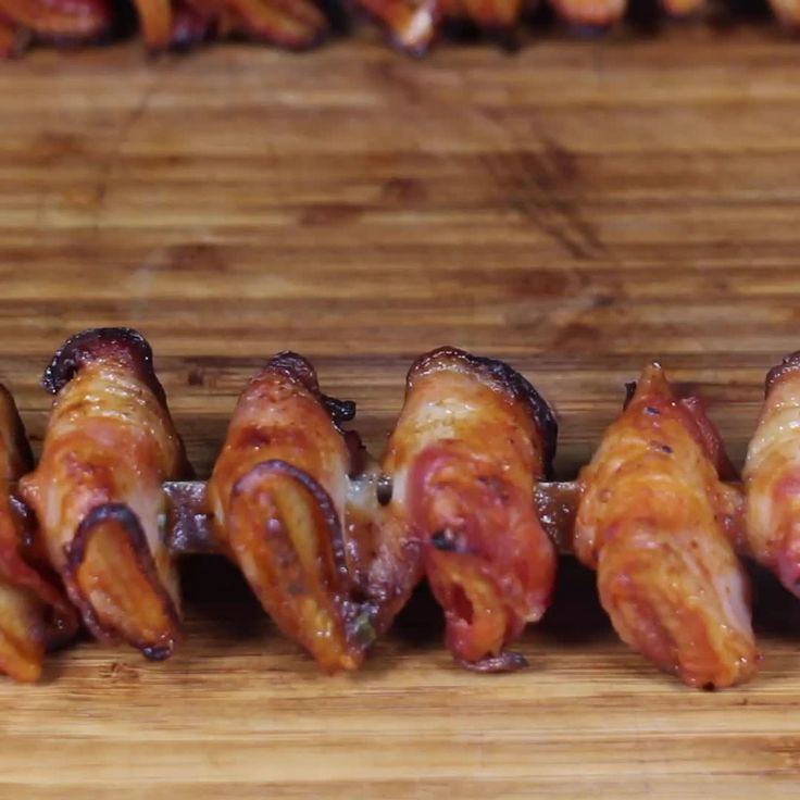 bacon wrapped in strips on a wooden cutting board