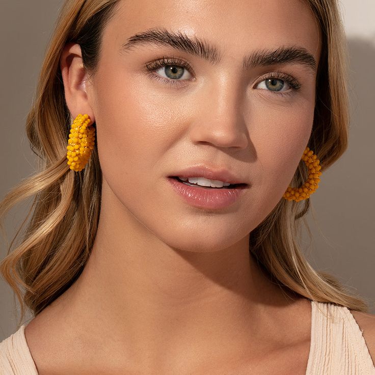 Make a statement this summer with our Beaded Hoops. These dark yellow beaded earrings pair perfectly with all of your favorite gold earrings and all of our other beaded jewelry. Add these statement hoop earrings to your collection and you’ll have an unforgettable look all season long. Trendy Yellow Earrings With Colorful Beads, Trendy Yellow Beaded Earrings, Gold Beaded Earrings For Beach, Summer Yellow Hoop Jewelry, Colorful Beads Hoop Earrings For Beach, Yellow Beaded Hoop Earrings For Summer, Yellow Beaded Drop Earrings For Summer, Gold Beaded Hoop Earrings For Summer, Yellow Hoop Earrings For Summer Beach