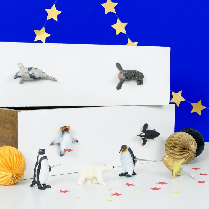 several small figurines are placed in front of two boxes with animals on them