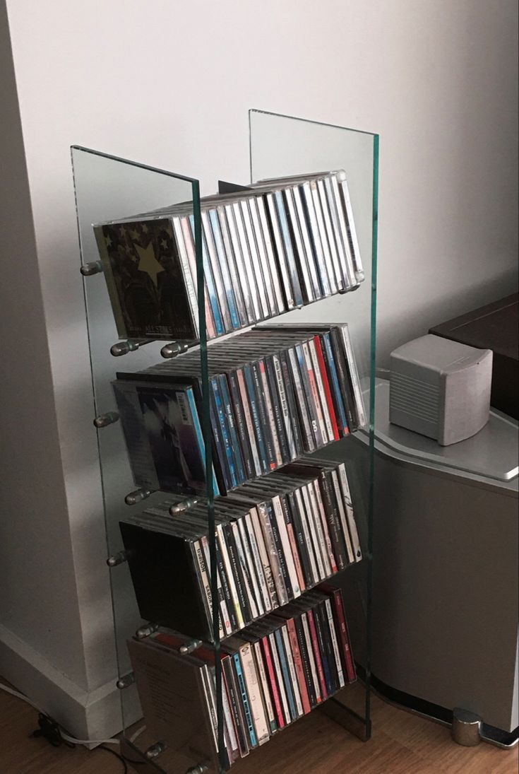 a stack of cd's sitting on top of a shelf next to a speaker