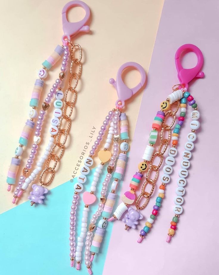 two pairs of scissors and some beaded bracelets on top of a pink and blue background