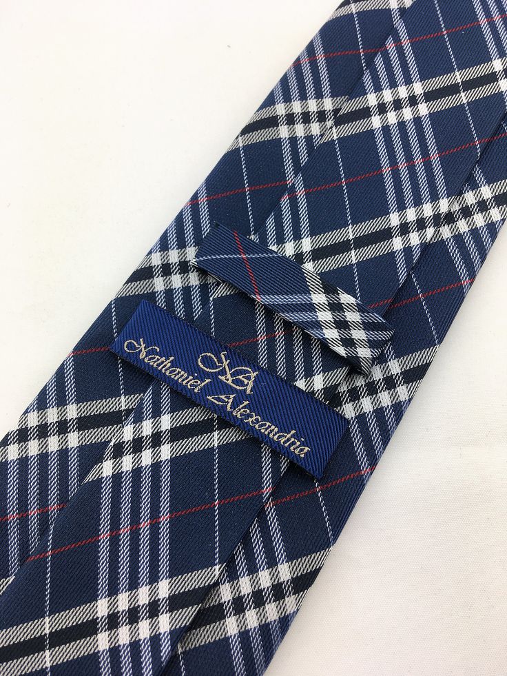 "For the man who loves plaid, Ed's Neckties offers this 100% silk mens plain necktie. Features a navy blue background with blue, gray and red plaid pattern. Available as a extra long tie. Handmade from 100% silk, this special collection features a .75\" Eds Neckties logo at the bottom right front corner of every tie and a larger logo located on the tipping (Back of the tie). The label features the collection name (Nathaniel Alexandria) Named after my son Nathaniel and my daughter Alexandria. Exp Classic Plaid Business Suit And Tie Accessories, Fitted Plaid Ties, Classic Plaid Ties For Formal Occasions, Classic Ties For Father's Day, Classic Plaid Standard Tie, Classic Plaid Suit And Tie Accessories For Office, Plaid Suit And Tie Accessories For Business, Navy Suit And Tie Accessories For Business, Make A Tie