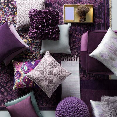 purple and white pillows are arranged on the wall